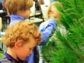 Children, youth and parents decorating the Mitten Tree with hats, scarves, gloves and mittens.