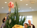 Children, youth and parents decorating the Mitten Tree with hats, scarves, gloves and mittens.
