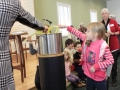 Putting vegetables in the Stone Soup pot.